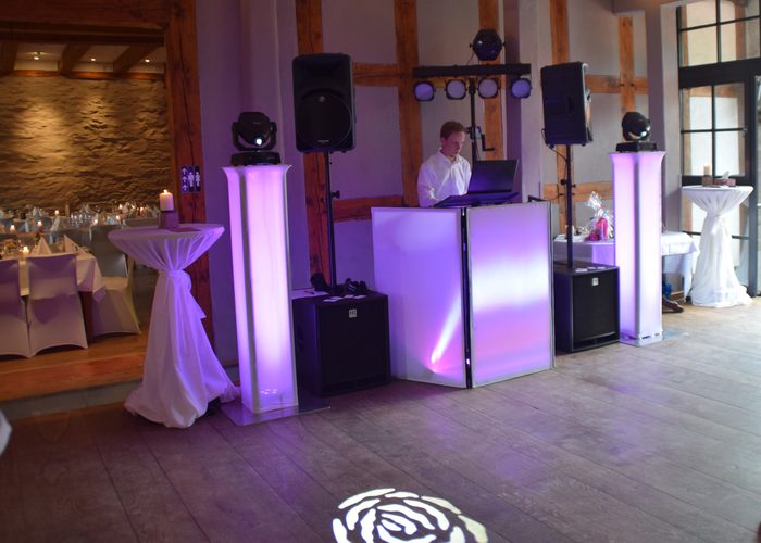 DJ-Set bei einer Hochzeitsfeier mit violettem Ambientelicht